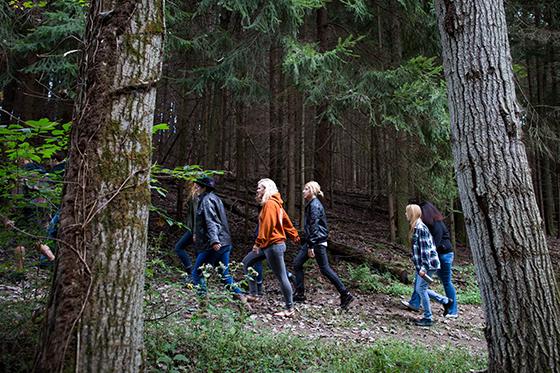 Photo of students walking through a forest on Eden Hall Campus